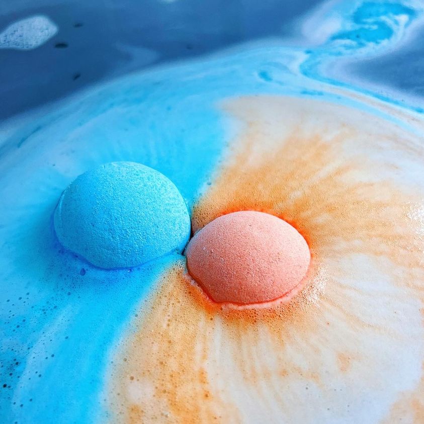 Uranus and Venus bath bomb dissolving in water with colourful swirls